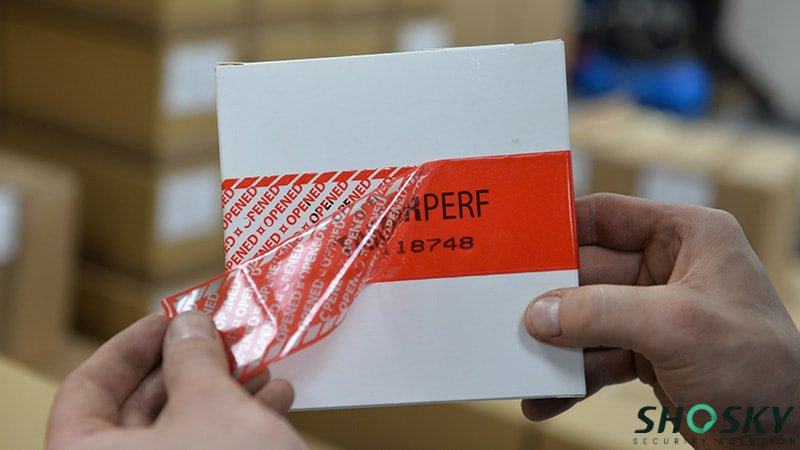 someone is removing the tamper proof tape on the box
