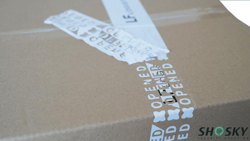 Partial transfer security tape peeled on a shipping box showing tamper evidence
