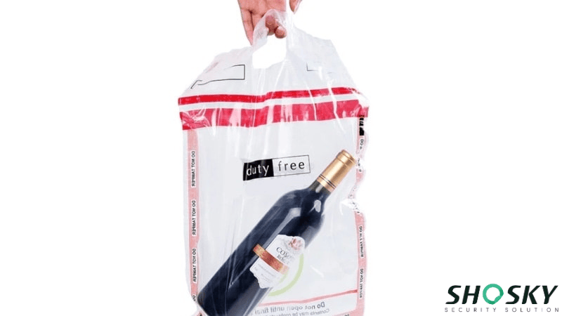 Hand holding custom duty-free bag with bottle inside