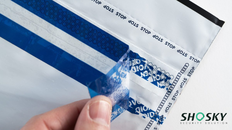 Durable tamper-evident tape being peeled from a bag, exposing a "VOID" pattern that signals tampering