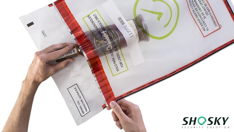 Hands holding a transparent duty-free bag with a red seal and a liquid product inside