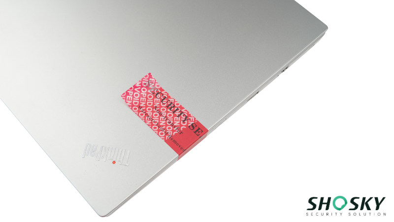 laptop sealed with a security label, showing irreversible damage when removed