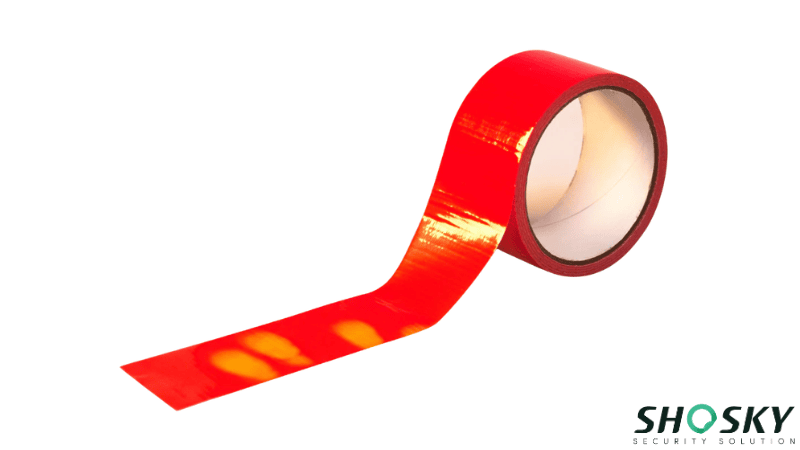 Roll of red heat-sensitive security tape showing color change from touch.
