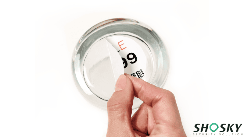 a man is peeling off a repositionable adhesive label used on a glass cup
