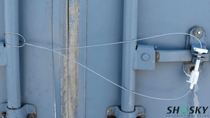 White high-security cable seal locking the door handles of a blue shipping container
