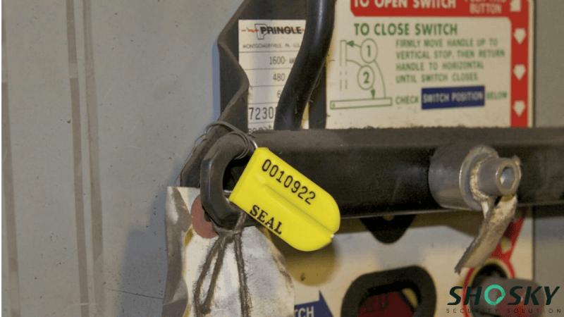Yellow plastic padlock seal with unique serial number 0010922 installed on a Pringle industrial electrical switch for security locking
