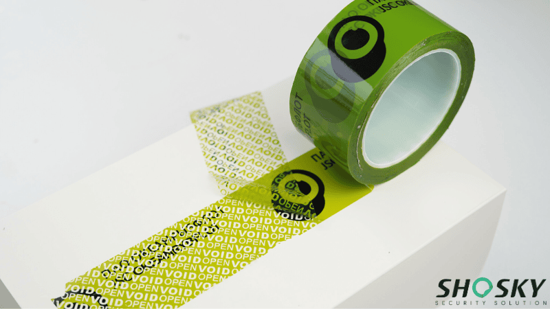 Custom branded green security tape for cold weather being peeled back to reveal a hidden "VOID OPEN" message on the surface