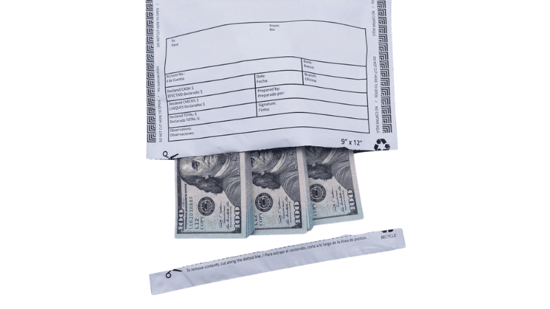 A white security deposit bag cut open at the bottom to reveal stacks of 100 US dollar inside