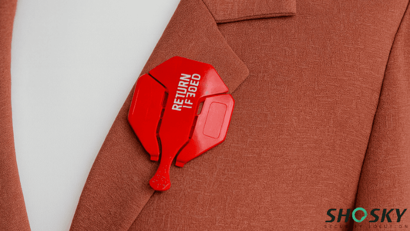 A red Anti-Return-Fraud Smart Tag printed with "RETURN IF REMOVED" attached to the lapel of a brown blazer jacket