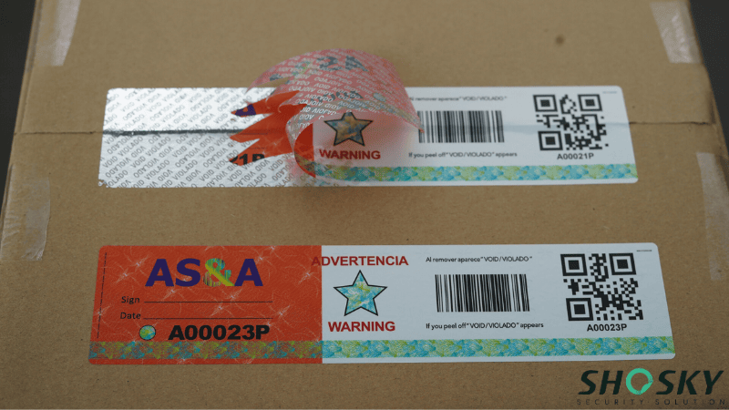 A cardboard box sealed with custom barcode security tape, showing one label peeled back to reveal a hidden "VOID" tamper message alongside a barcode and QR code.