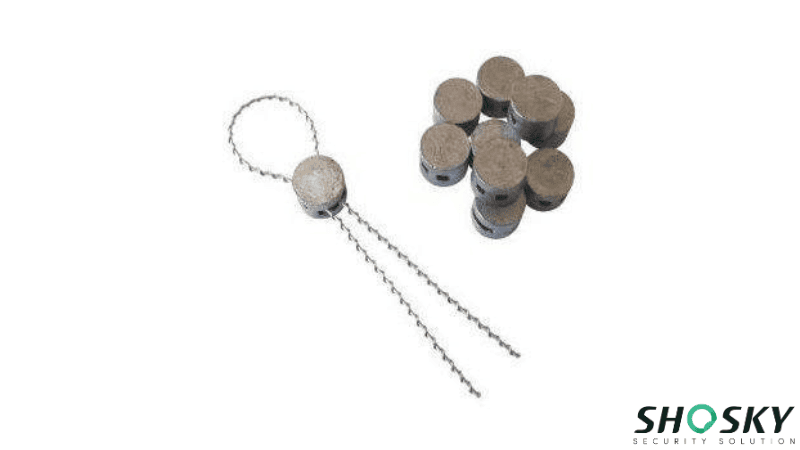 Traditional round lead seal, with one seal attached and crimped onto a twisted security wire.