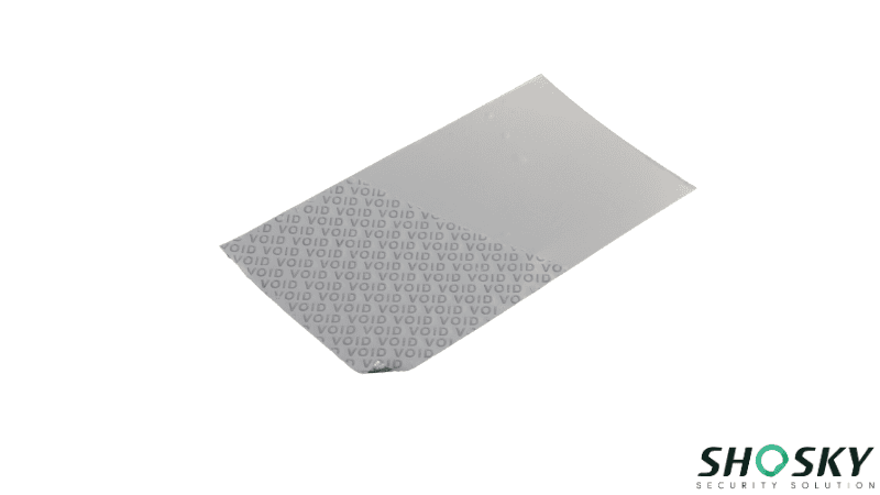 A non-transfer silver tamper evident material with a peeled-back corner revealing a repetitive "VOID" security pattern.