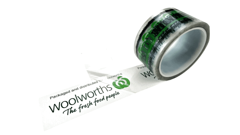 A roll of custom-printed total transfer tamper evident void tape branded for Woolworths, unrolled to show green printed text and a clear film backing.