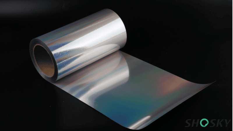 Roll of hologram destructible vinyl material showing iridescent rainbow reflections for tamper-evident security label manufacturing